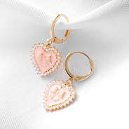 rhinestone heart earrings on white sheet
