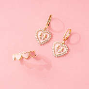 rhinestone heart earrings with heart ring on pink paper