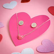 monogrammed heart necklace set on pink paper with hearts