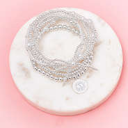 silver pearl bow bracelet stack in marble dish