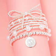 silver pearl bow bracelet stack on pink background