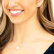 silver cross necklace on neck