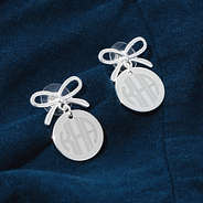 silver bow dangle earrings on blue background