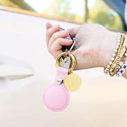 pink with gold airtag key chain in hand