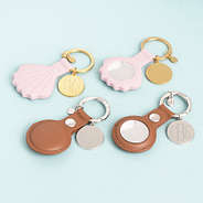 duo airtag key chains in pink and brown on blue background