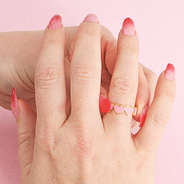 girl putting on pink gold heart ring