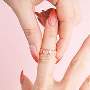 ​​pink and gold heart ring on finger
