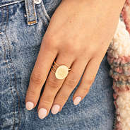 engraved golden statement ring on finger