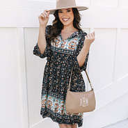 girl with monogrammed shoulder bag in taupe over arm