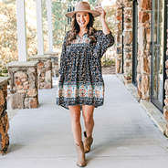 puff sleeve black paisley dress with wide brim hat and cowboy boots