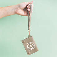 girl holding taupe monogrammed card holder wristlet