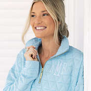 close up of girl wearing monogrammed quilted quarter zip pullover in ice blue