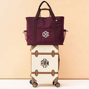 monogrammed carry on tote in burgundy on suitcase luggage