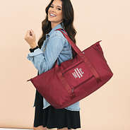 girl carrying monogrammed carry on weekender in crimson