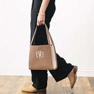 girl holding monogrammed shoulder tote in brown