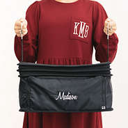 girl carrying collapsed monogrammed hanging packing organizer in black