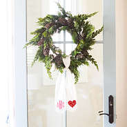 wreath on door with monogram and hearts on a wreath sash