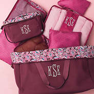 Burgundy Woodland Blossom foldover cosmetic case spill shot with packing bag set and foldover weekend bag