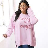 girl wearing merry and bright sweatshirt in light pink