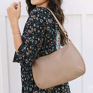 girl with foil monogrammed shoulder bag in taupe over shoulder