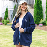 girl wearing navy monogrammed sweatshirt jacket with baseball hat
