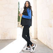 girl wearing blue long sleeve crewneck sweatshirt with black puffer vest