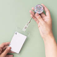 girl holding monogrammed coral floral badge reel