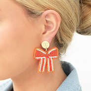 orange gameday bow earrings in ear
