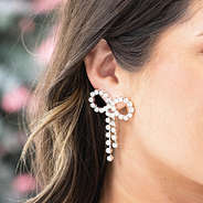 silver rhinestone bow earrings in ear