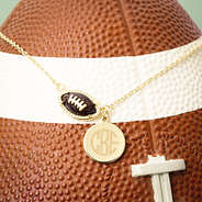 brown football necklace on football