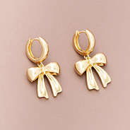 bow huggie hoop earrings on brown background