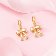 bow huggie hoop earrings on pink background