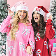 girls wearing monogrammed santa hats in red and pink