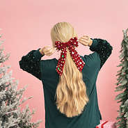 girl touching christmas velvet bow back