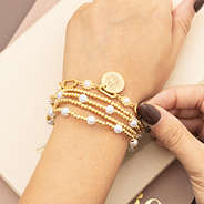 pearl starburst gold monogrammed bracelet on wrist