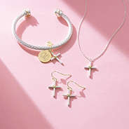 cable cross necklace bracelet and earrings on pink