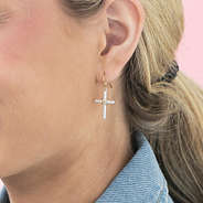 girl wearing cable cross earrings