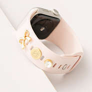 up close of monogrammed bow smartwatch charm set in gold on watch