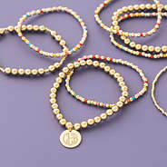 Colorful bracelet stack on purple