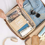 personalized large clear toiletry case in gold in luggage packed