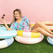 girl wearing monogrammed cinch waist cover up in flamingo splish splash in pool floatie