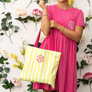 ava holding yellow and pink striped tote on arm