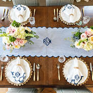 navy seersucker scalloped table runner on table with settings
