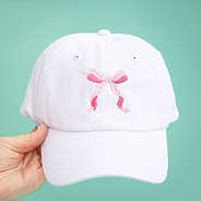 bow baseball hat on green background