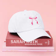 white bow baseball hat on books