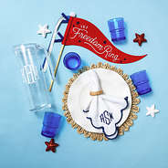 blue acrylic pitcher with nesting cups flatlay with flag and napkin