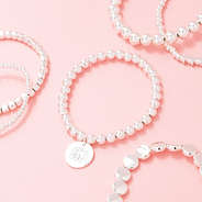 silver lightweight bracelets scattered on pink