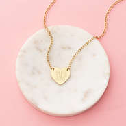 gold heart pendant necklace on marble dish