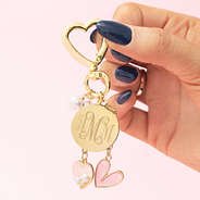 monogrammed gold bag charm keychain in hands