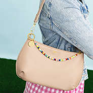 multi bag charm keychain on shoulder bag worn by girl